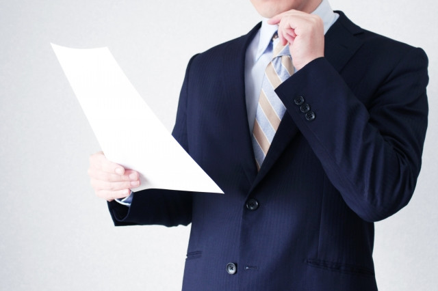 書類を持つスーツの男性